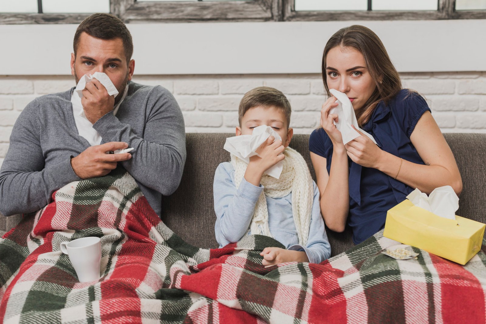 Pai, filho e mãe com lenços com aparência de gripe